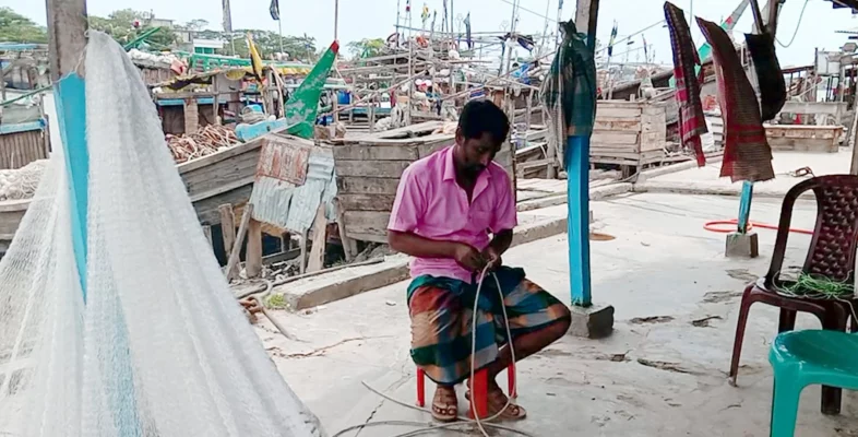 জাল মেরামতের কাজে ব্যস্ত এক জেলে