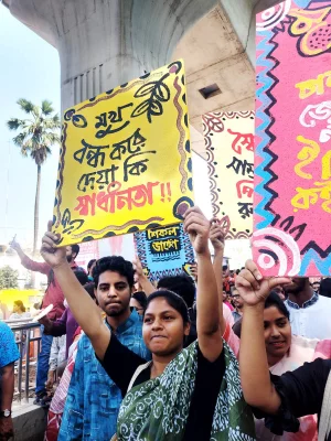 ‘মুখ বন্ধ করে দেওয়া কি স্বাধীনতা’ সংবলিত প্ল্যাকার্ড হাতে এক নারী