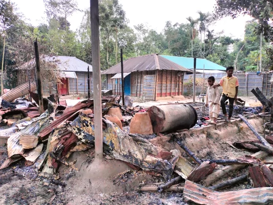 আগুনে পুড়ে যাওয়া ঘরের কাঠামোর কাঠ দেখাচ্ছেন ফজিলা বেগম