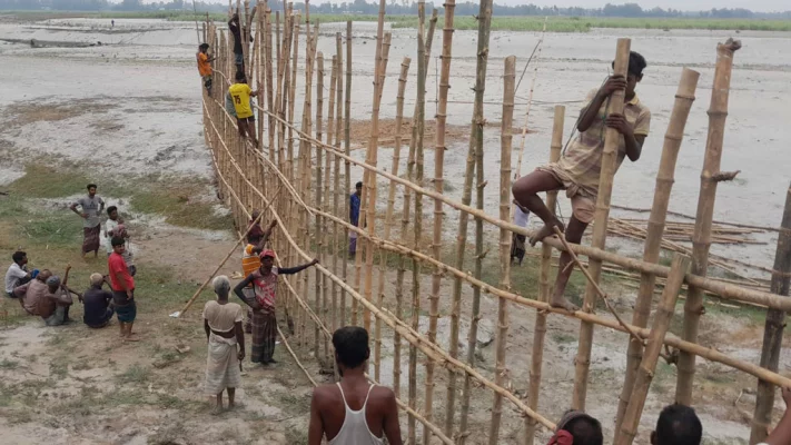 বাঁশের বাঁধ তৈরির কাজে অংশ নিয়েছেন এলাকার বয়স্ক, যুবক, তরুণ ও কিশোরেরা। ছবি: সংগৃহীত