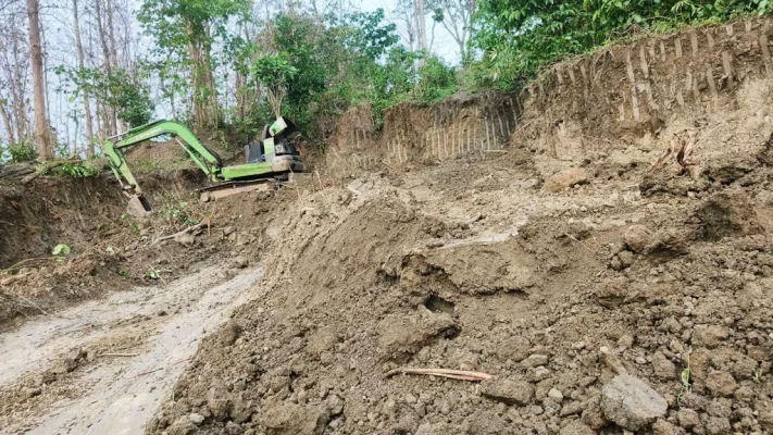 থানচি বাস স্টেশনের টিকিট কাউন্টারে পিছনে কাটা হচ্ছে পাহাড়।  ছবি: আজকের পত্রিকা