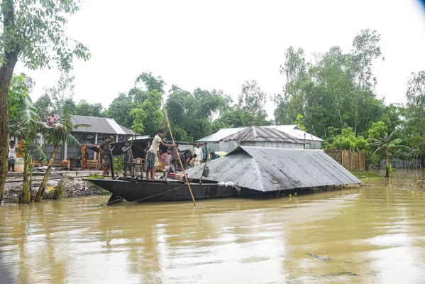 ভাঙন আতঙ্কে তাদের ঘর-বাড়ি নৌকায় করে সরিয়ে নিচ্ছে একটি পরিবার। মর্ণেয়া ইউনিয়নের আলফাজটারী থেকে তোলা। ছবি: আজকের পত্রিকা