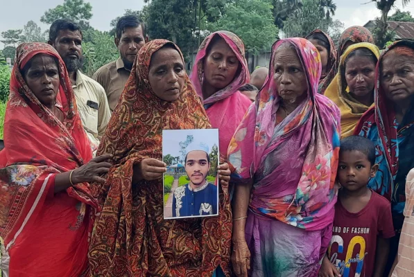 কবরের পাশে ছেলের ছবি হাতে মা শাহনাজ বেগম। ছবি: সংগৃহীত  