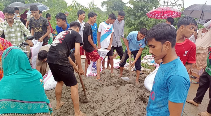 ক্ষতিগ্রস্ত গোমতী বাঁধ বালুর বস্তা দিয়ে মেরামত করছেন স্থানীয়রা। ছবি: আজকের পত্রিকা 