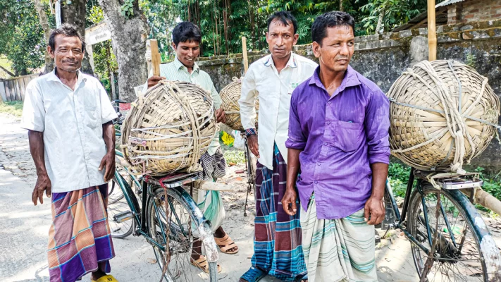 গঙ্গাচড়া মেডিকেল মোড় এলাকায় সাইকেল চালিয়ে যাচ্ছেন কয়েকজন শ্রমজীবী মানুষ। ছবি: আজকের পত্রিকা