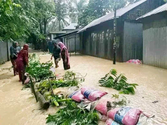 চেল্লাখালি নদীর পানিতে তলিয়েছে লোকালয়। জানমাল রক্ষায় রাস্তায় বাঁধ দেওয়া হচ্ছে। শুক্রবার বাঁধবেড় এলাকায়। ছবি: আজকের পত্রিকা