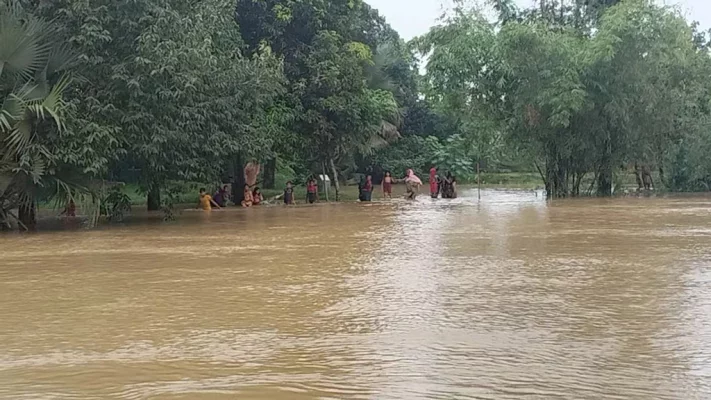 দুর্গাপুর উপজেলার কাকৈরগড়া ইউনিয়নের রামবাড়ি গ্রামে পানি মাড়িয়ে গন্তব্যে যাচ্ছেন নারী ও শিশুরা। ছবি: আজকের পত্রিকা